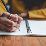 Close up woman hand writing on notebook