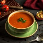 tomato soup with green on the table