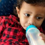 young-indian-boy-drinking-milk-from-bottle