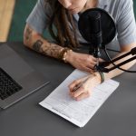 high-angle-woman-taking-notes-podcast