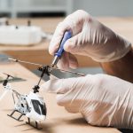 male-technician-hand-repairing-helicopter-toy