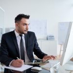 busy-caucasian-man-suit-sitting-office-working-computer