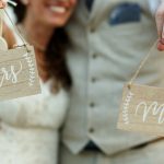 happy-newlyweds-hold-wooden-boards-with-letterings-mrs-mr